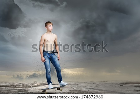 Skater in jeans on road with tornado at background
