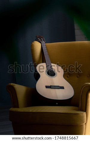 Classic acoustic guitar on the yellow arm chair