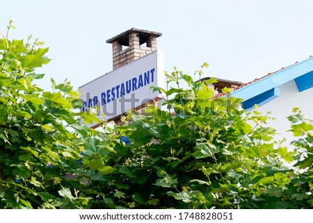 bar restaurant sign on roof urban facade building