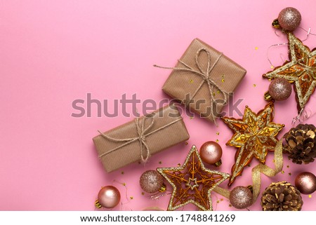 Christmas composition with toys, gifts, stars, balls and tinsel on a pink background. Flat lay, top view.