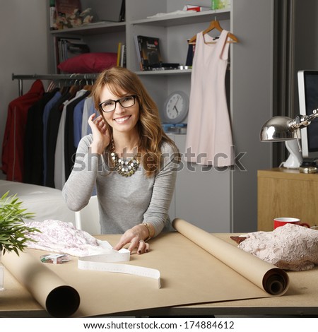 Mature fashion designer working in her studio.