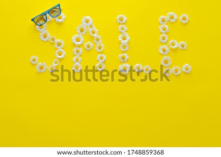 Word with daisies sale on a yellow background