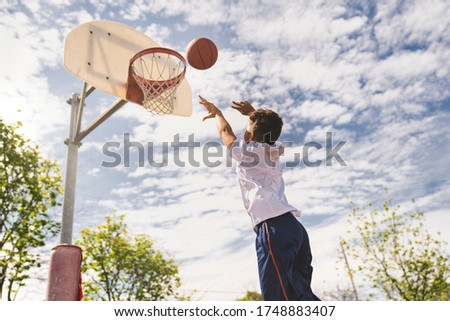 A nice and cool Afro american players playing basketball outdoors