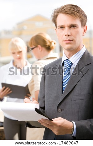 Photo of confident man looking at camera in working environment