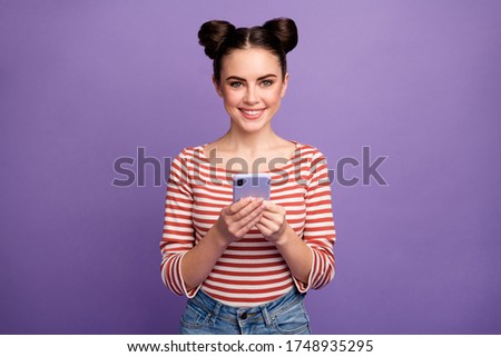 Photo of pretty lady two buns hold telephone hands check followers subscribers addicted blogger wear white red casual striped shirt isolated purple pastel color background