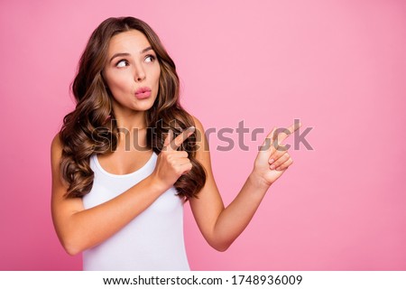 Photo of charming wavy lady sales manager indicate fingers hands side empty space advising cool offer low prices wear white casual singlet isolated pink color background