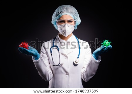 Photo of serious lady doc hold red green covid two bacteria demonstrating difference comparison analysis wear gloves mask coat facial plastic surgical cap isolated black color background Royalty-Free Stock Photo #1748937599