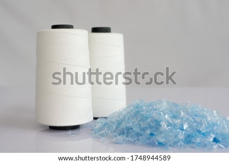 PET bottle flake or Plastic bottle crushed & Raw White Polyester FDY Yarn spool with white background Royalty-Free Stock Photo #1748944589