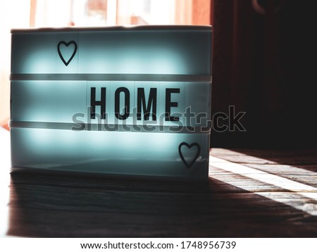 
Lightbox with heart and text  HOME glowing in light. 