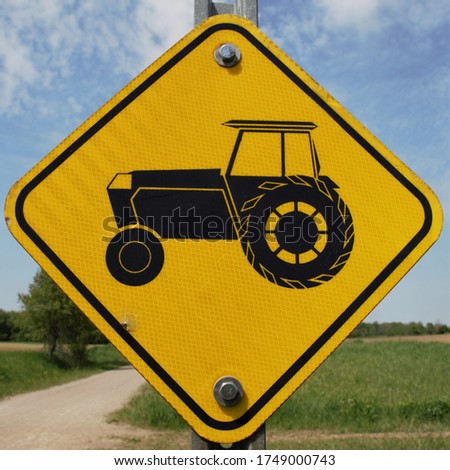 Tractor crossing amber farm sign