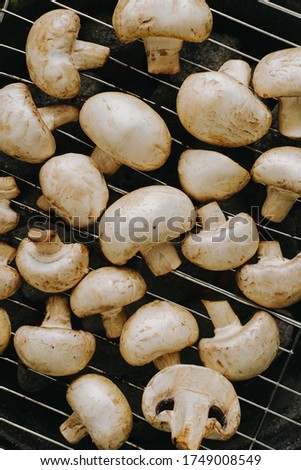 Cooking champignon mushrooms on the grill. Outdoor picnic