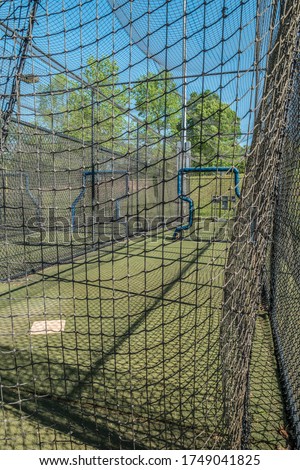 Empty and vacant batting cages at a baseball field in a park closed due to the Covid-19 pandemic in early springtime Royalty-Free Stock Photo #1749041825