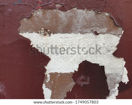 Grunge cracked red wall paint peeling off. Paint is peeling off, weather-beaten wall and it looked like a map