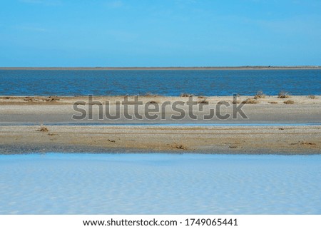 Sea landscape background. Sea ​​and salt lake, separated by a sand spit. Minimalistic landscape. Symmetry in nature. 