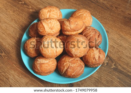 Home fried donuts during quarantine  on a blue plate on the wooden table.