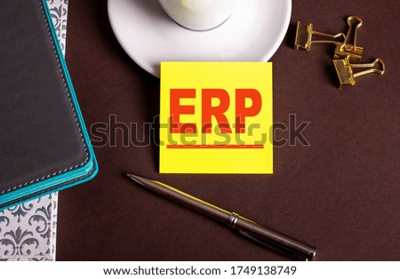The word ERP is written on a yellow sticker near the diaries and pens. Business concept