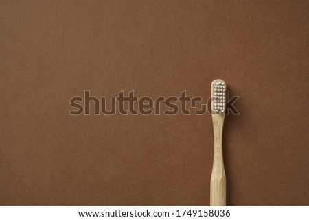 Bamboo toothbrush on carton background flat lay. Zero waste, eco lifestyle. Recyclable material.