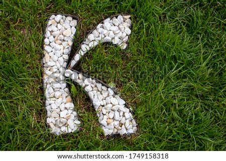 The letter K, an alphabet of white gravel stones.