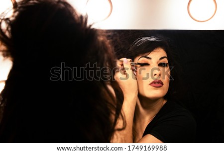 Beautiful young woman in Amy Winehouse style. She has a high fluffy hairstyle and expressive eye makeup. Royalty-Free Stock Photo #1749169988
