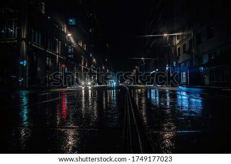 Lights of the night city. It's raining outside. Wet asphalt. Rails from the tram. Night time. Night city.