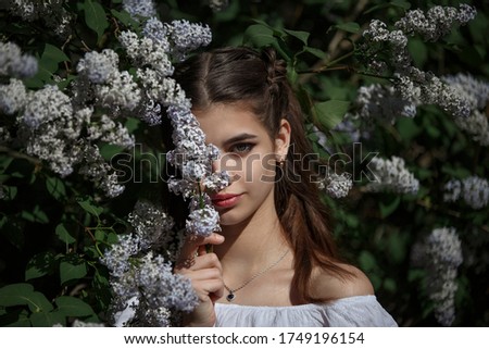 a girl in a white dress with lilac flowers