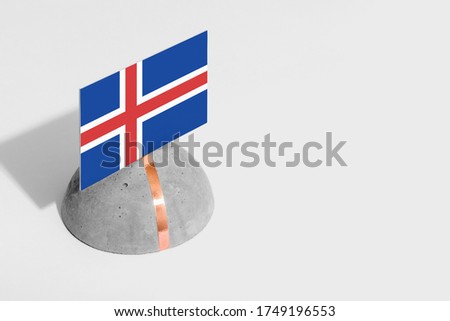 Iceland flag tagged on rounded stone. White isolated background. Side view minimal national concept.