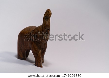 front view of a wooden carved elephant statue with trunk up