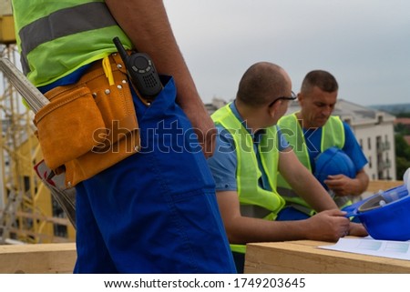 Workers gears close up while other workers make a break in the background picture