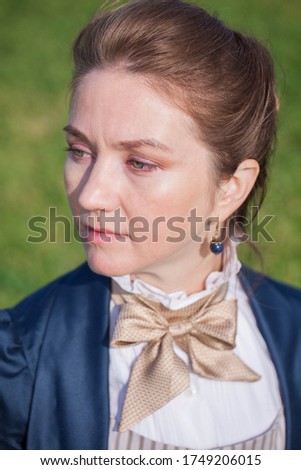 Portrait of a romantic young beautiful lady wearing victorian dress drinking outdoors. Vintage style. Steampunk concept