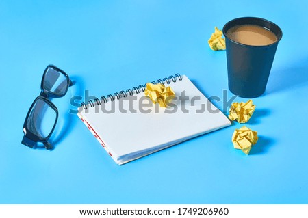 Office workplace with different accessories, tools and gadgets on blue table. Business concept