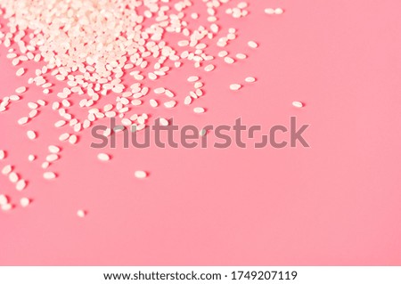 Scattered grain of rice on pink background. Copy space