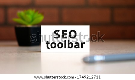 Seo toolbar text of business concept on white list and with pen and a black pot with a flower behind