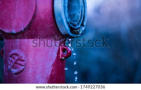 Close up of red fire hydrant with single water drops. Selective focus.