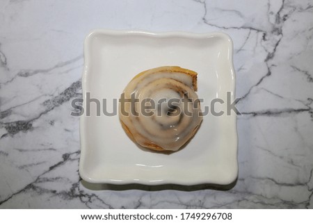 Top view of a freshly baked Cinnamon roll with icing on top.