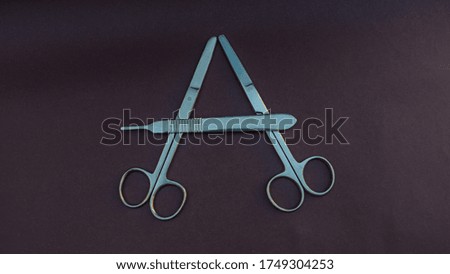 surgical scissors and forceps forming a letter A