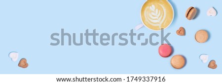 Blue background with macaroons and a Cup of coffee. Top view with space for your text.