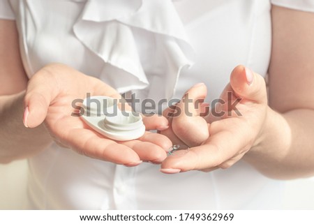 Eyesight and eyecare concept. Woman Hands Holding White Eyelense Container