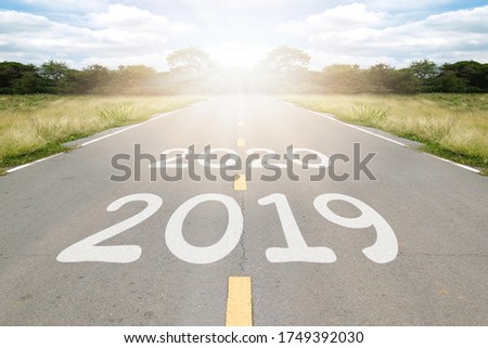 2020, 2019 word writen on asphalt road with natural background. Business concept.