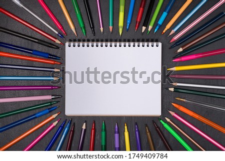 Education concept. Top above overhead view photo of colorful pens and pencils around blank with copyspace notebook isolated on blackboard