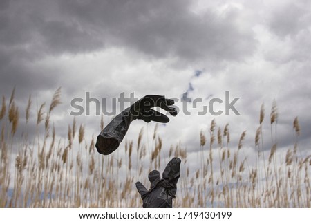 black medical gloves on sky background