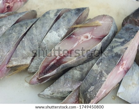 Salting of fresh red fish.  Sliced ​​fish into pieces.  Pieces of red fish lie on a cutting board.