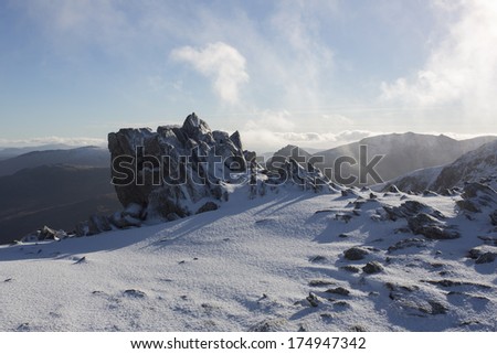 rocks covered in snow on mountain top in snowdonia, north wales