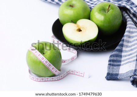 green apple with measuring tape on white background, healthy food concept