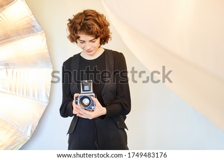 Young photographer inspects camera settings of her medium format camera