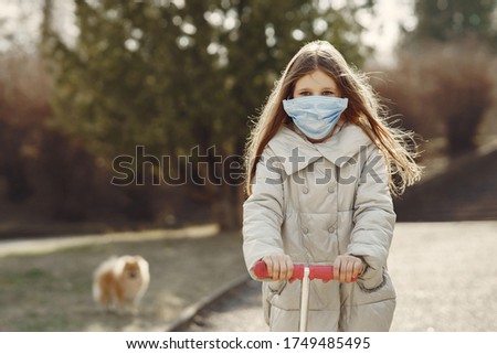 Child walks outside. Coronavirus theme. Girl in a skate.