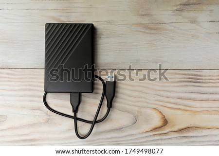 Portable hard drive for backing up various files on wood background