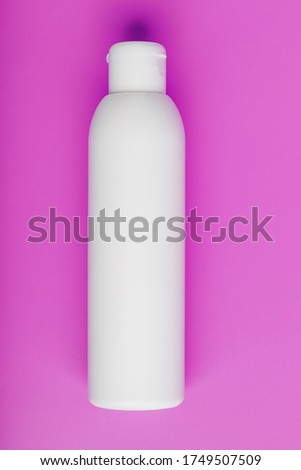 White bottle on pink background. Free space for text.
