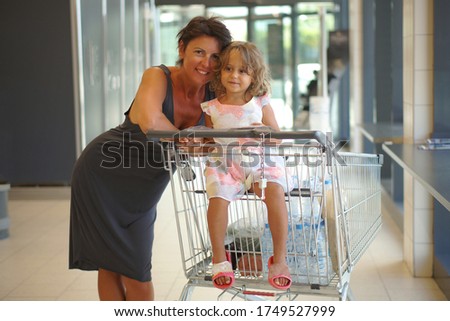 a 4 year old girl and her mother in a supermarket in Greece