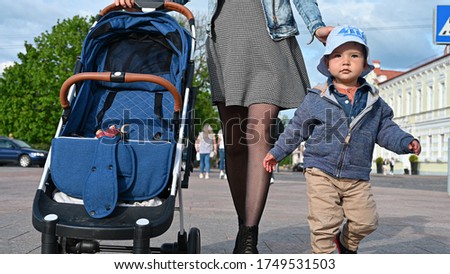 A child with mom and a stroller walk around the city
