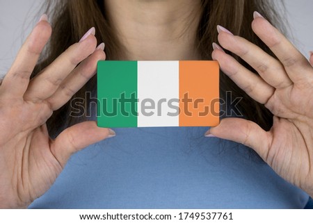 A woman shows a business card with an image of the Irish flag